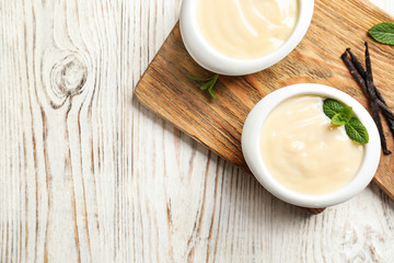 Vanilla pudding, sticks and fresh mint on wooden board