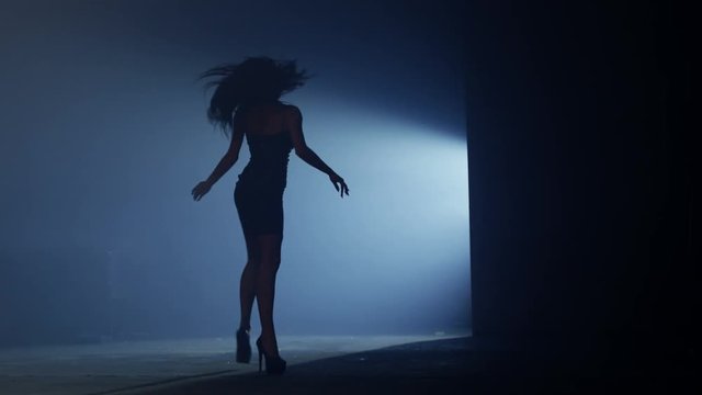 Beautiful dancer demonstrating her perfect sensual figure and dancing on dark blue background with strobe light effect . Shot on RED HELIUM Cinema Camera in slow motion.