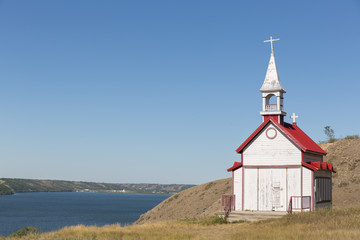 Fototapeta na wymiar little white church with a red roof on a hill side