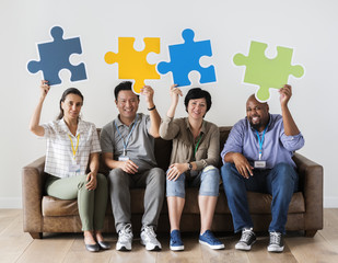 Workers sitting and holding puzzle icons