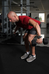 Fototapeta na wymiar Muscular Man Doing Heavy Weight Exercise For Back
