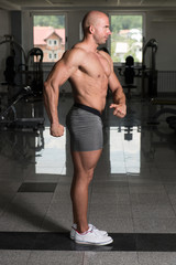 Fototapeta na wymiar Man in Gym Showing His Well Trained Body