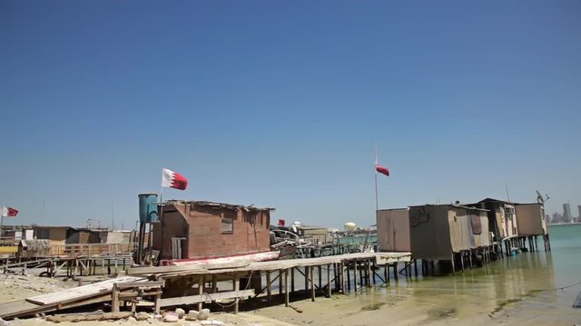 Baharian. Fishermen Houses and Bahraini Flags