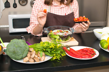 beautiful woman cooking in new kitchen making healthy food with vegetables.