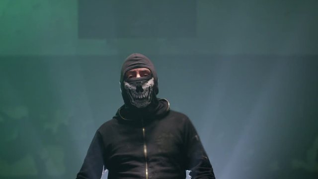 Portrait of bandit with mask and baseball bat on dark room. Shot on RED cinema camera .