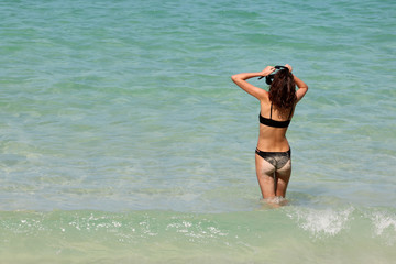 Tourists teenage girl enjoying to use the snorkel on the beach.