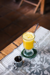 Turmeric golden latte on coconut milk at the restaurant. Vegan raw food concept. Drink photography