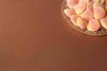 Bowl of sugared jelly sweets in crystal cut glass dish - on minimal bronze/copper background - corner design element, copy space