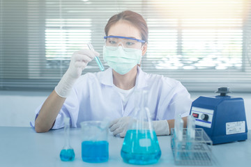 Professional distinguished Science specialist at work.Young Asian scientist with test tube making research in clinical laboratory.Innovative technologies in science and medicine