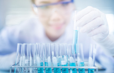Asian women scientist with test tube making research in clinical laboratory.Science, chemistry, technology, biology and people concept