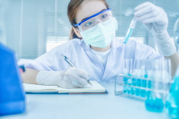 Asian women scientist with test tube making research in clinical laboratory.Science, chemistry, technology, biology and people concept