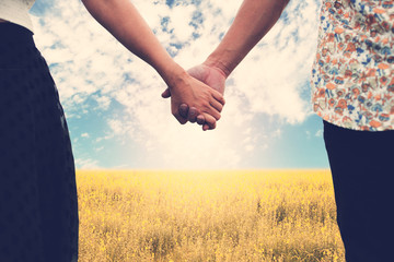 Couple holding hands and blurry beautiful nature in background