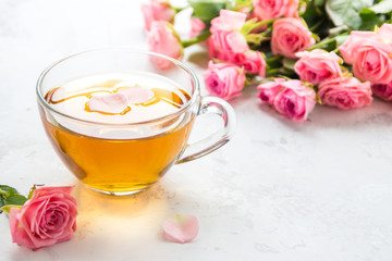 Cup of tea and tender pink roses on a white background copy space