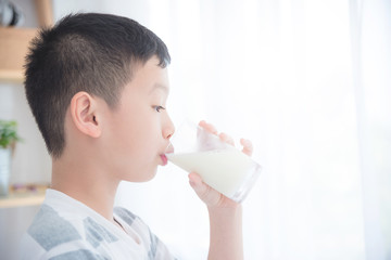 Young asian boy drinking a glass of milk for breakfast in the morning