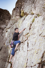 Naklejka premium man climbing a rock wall