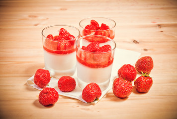 Italian dessert panna cotta with strawberry in small transparent glasses. Selective focus.