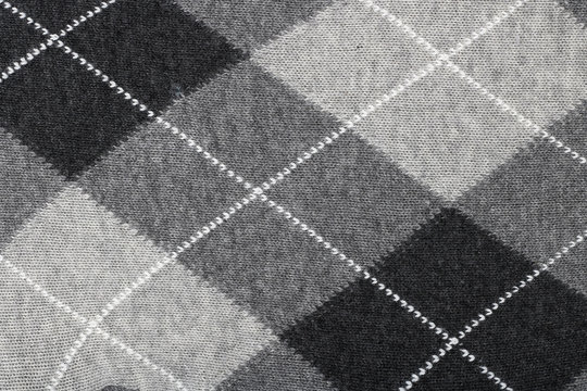 Pattern of a warm female sweater from black and white rhombuses and lines