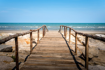 Fototapeta na wymiar Wooden bridge walkway to the sea beach