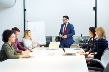 Businessman giving a presentation on flip chart. Teamwork concept