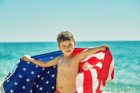 Boy at the beach holding a USA flag