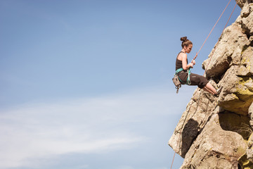 women climbing a rock wall