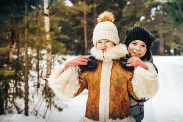 Children have fun in pein forest full of snow in a winter day