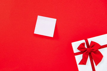 Empty notepaper on red background with gift box