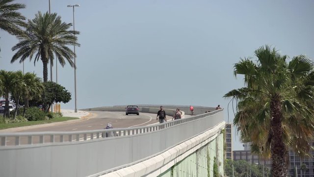 People walking and cars driving on a bridge