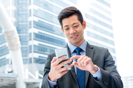 Young handsome Asian businessman  using mobile phone surfing internet