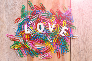 Valentine's day love Letter with series of colorful paper clips isolated on wooden board background with copy space.