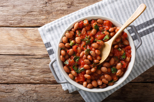 Stewed Cranberry Beans Or Borlotti In Tomato Sauce With Herbs Close-up In A Bowl. Horizontal Top View From Above