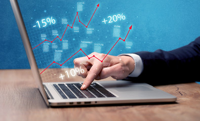 Salesman working on graph with laptop