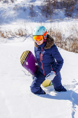 Photo of female athlete wearing helmet with snowboard
