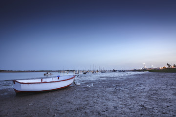 Naklejka premium small boat on the shore of the sea at dusk