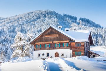 Fototapeta premium Traditional farmhouse in winter wonderland in the Alps