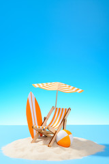 Paradise island in the ocean. Miniature beach accessories for outdoor activities. Blue background with copy space