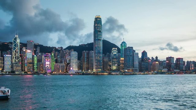 Hong Kong, China, day to night time lapse view of skyline and Victoria Harbour, zoom out.
