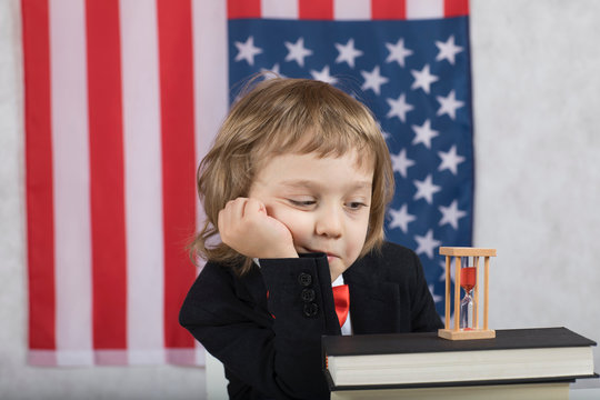 Boy of four years in front of American flag.