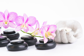 Obraz na płótnie Canvas Spa concept with hot stones, orchids and tealight close up