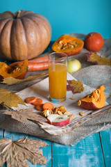 Glass of pumpkin juice on wooden surface.
