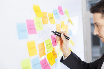 Creative man use post-it notes to share idea