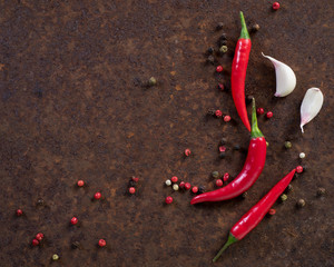 red hot chili pepper pods and peas, garlic clove on dark rusty metal background, top view, copy...