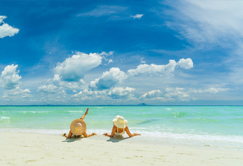 Fototapeta na wymiar Two women relaxing at the White sand beach