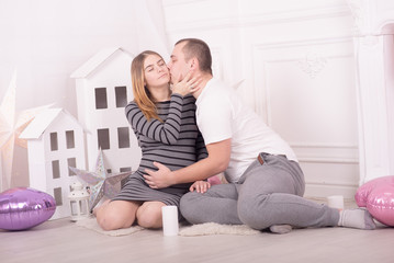 Fototapeta na wymiar Young pretty pregnant woman and her husband at home