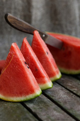 Slices of watermelon on wooden surface.