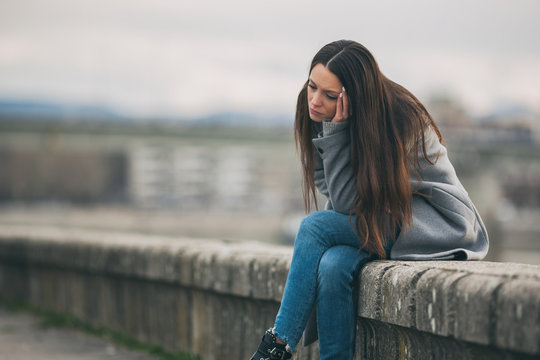 Young lonely and depressed woman is sitting in grief.