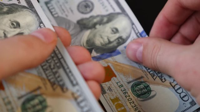 Close-up converting hundred dollar bills manually. first person video