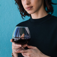 beautiful brunette woman with red wine glass blue background