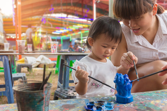 Asian cute girl baby and mother is painting colorful.