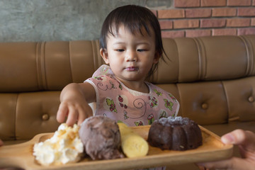 Cute baby girl enjoy eatting chocolate lava set.